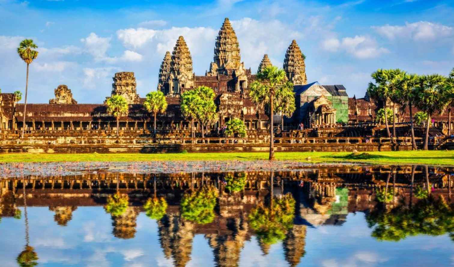 Reflection of Angkor Wat in water with surrounding greenery in Siem Reap