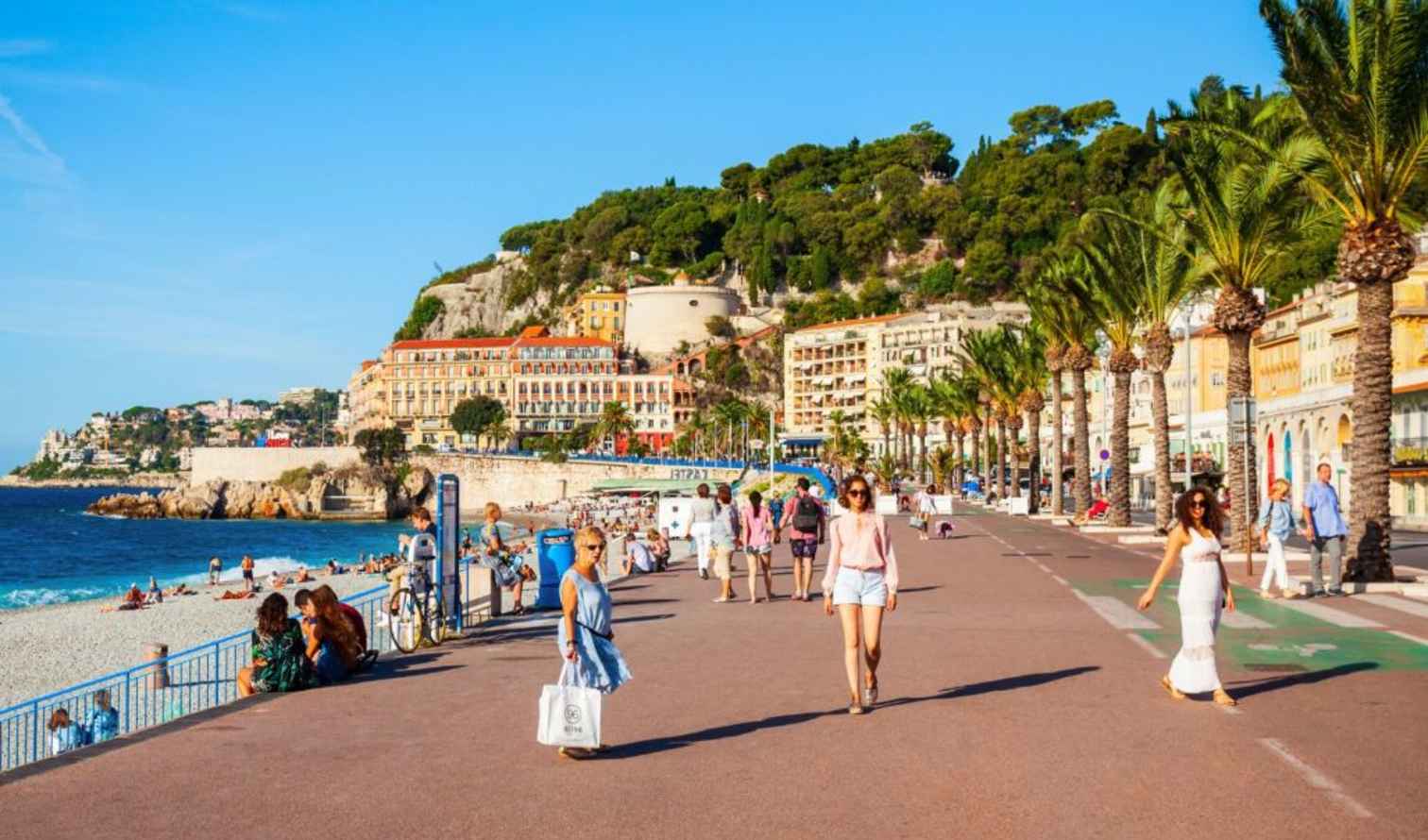 Sunny day on the Promenade des Anglais, Nice, with beach in view.