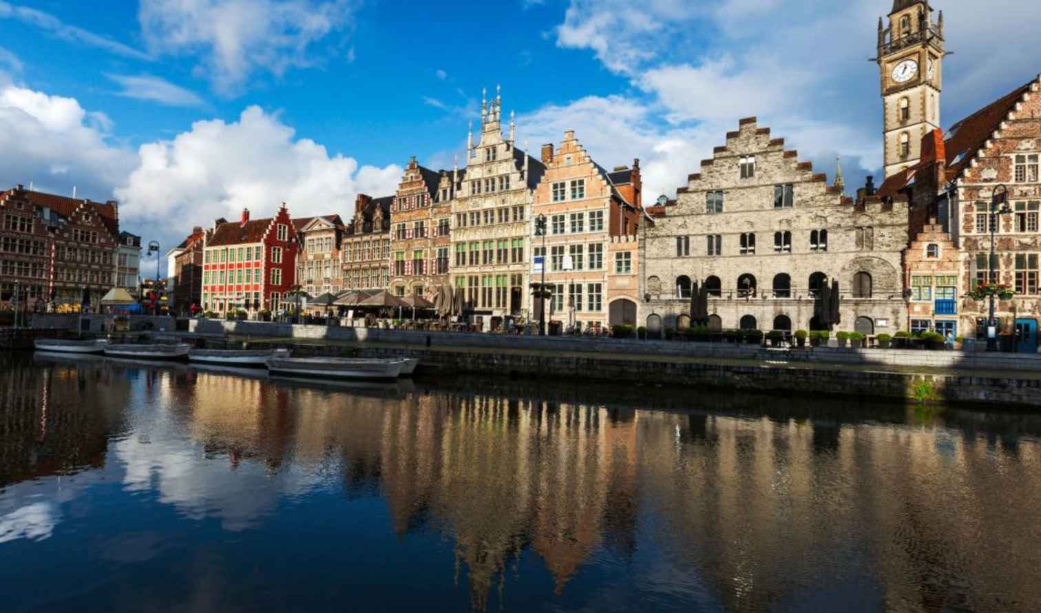Row of historical buildings along the Graslei in Ghent, Belgium, with canal view.