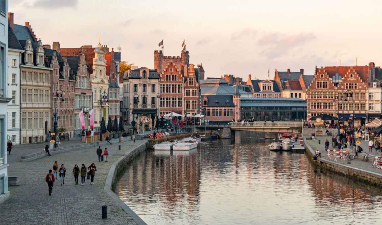 People walking along the Graslei waterfront in Ghent, Belgium.