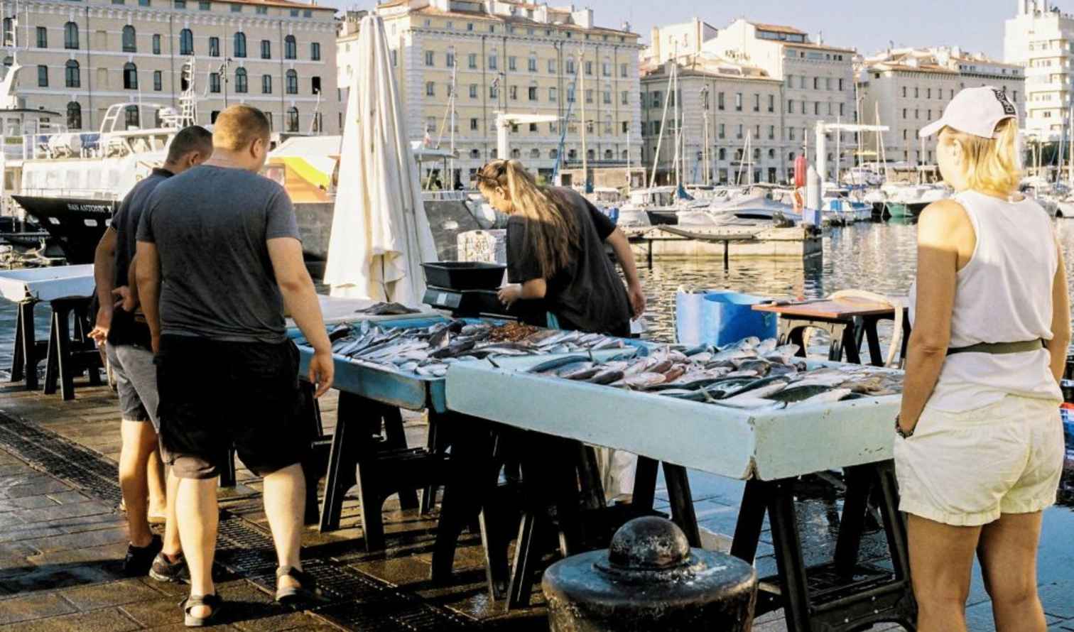 Porto Vecchio waterfront with seafood stand and browsing shoppers  in Marseille