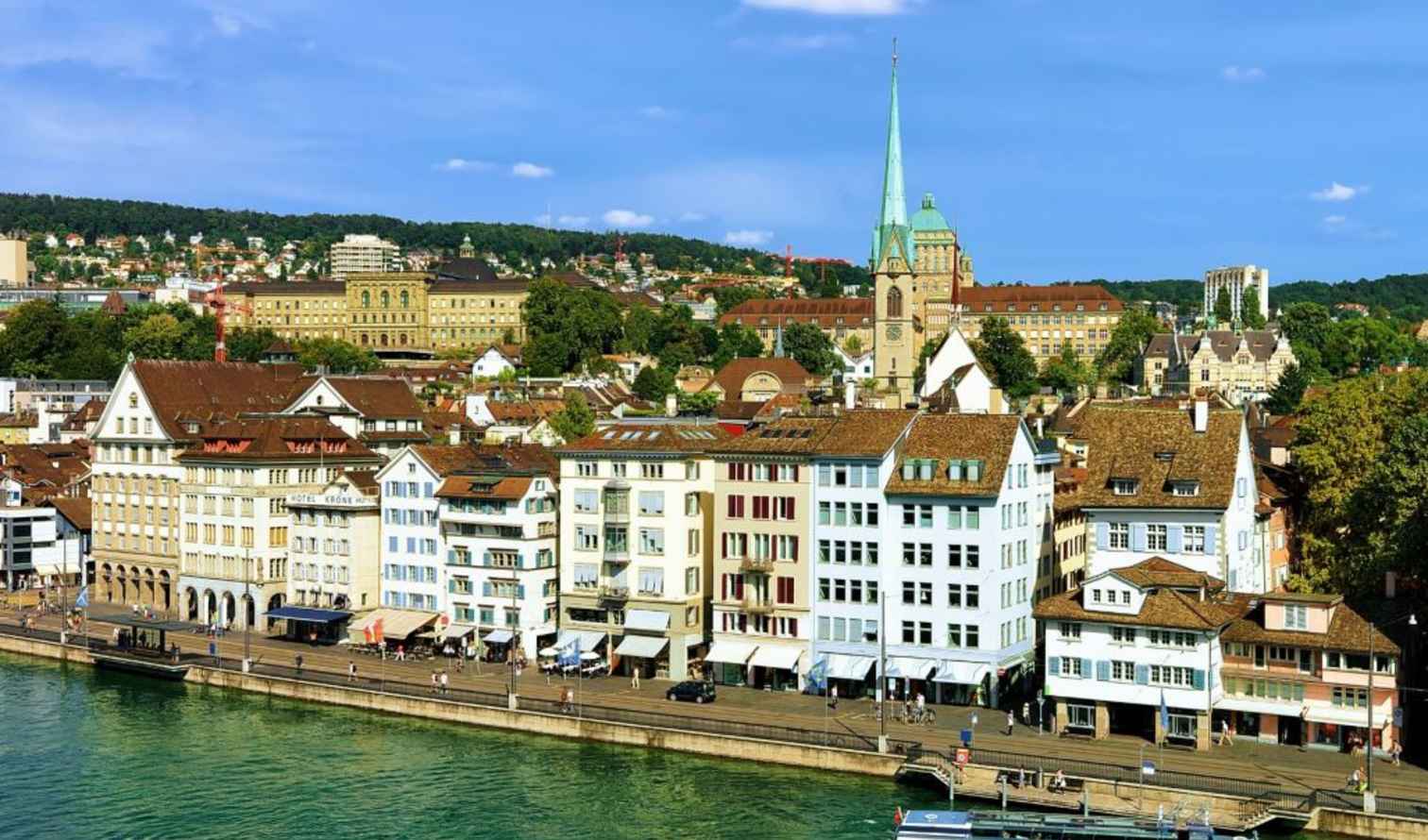 Fraümunster Church spire visible among historic buildings in Zürich, Switzerland.