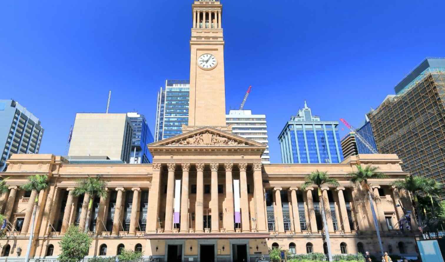 Brisbane City Hall with clock tower against a clear blue sky.