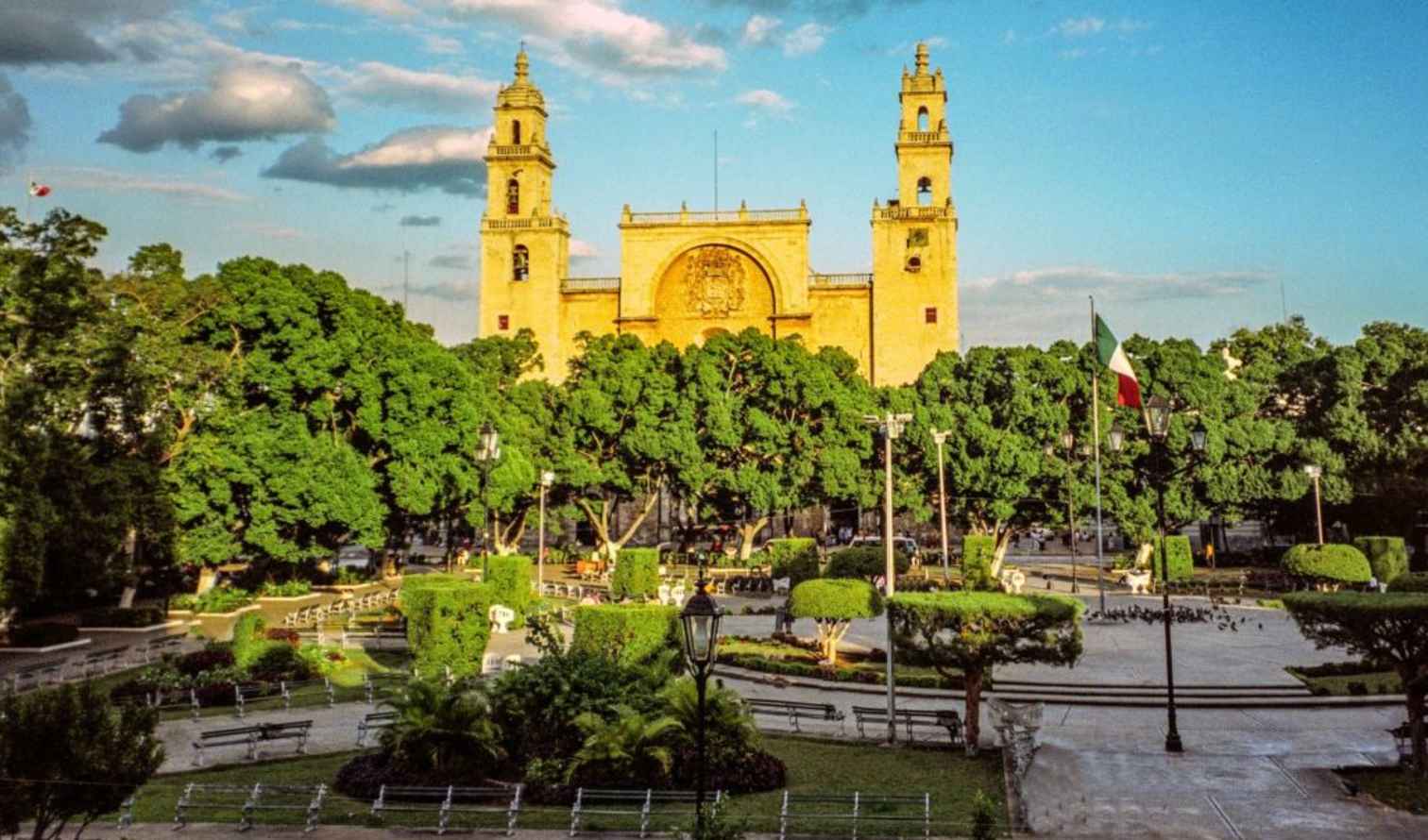 Panoramic view of Mérida Cathedral and Mexican flag in Plaza Grande.