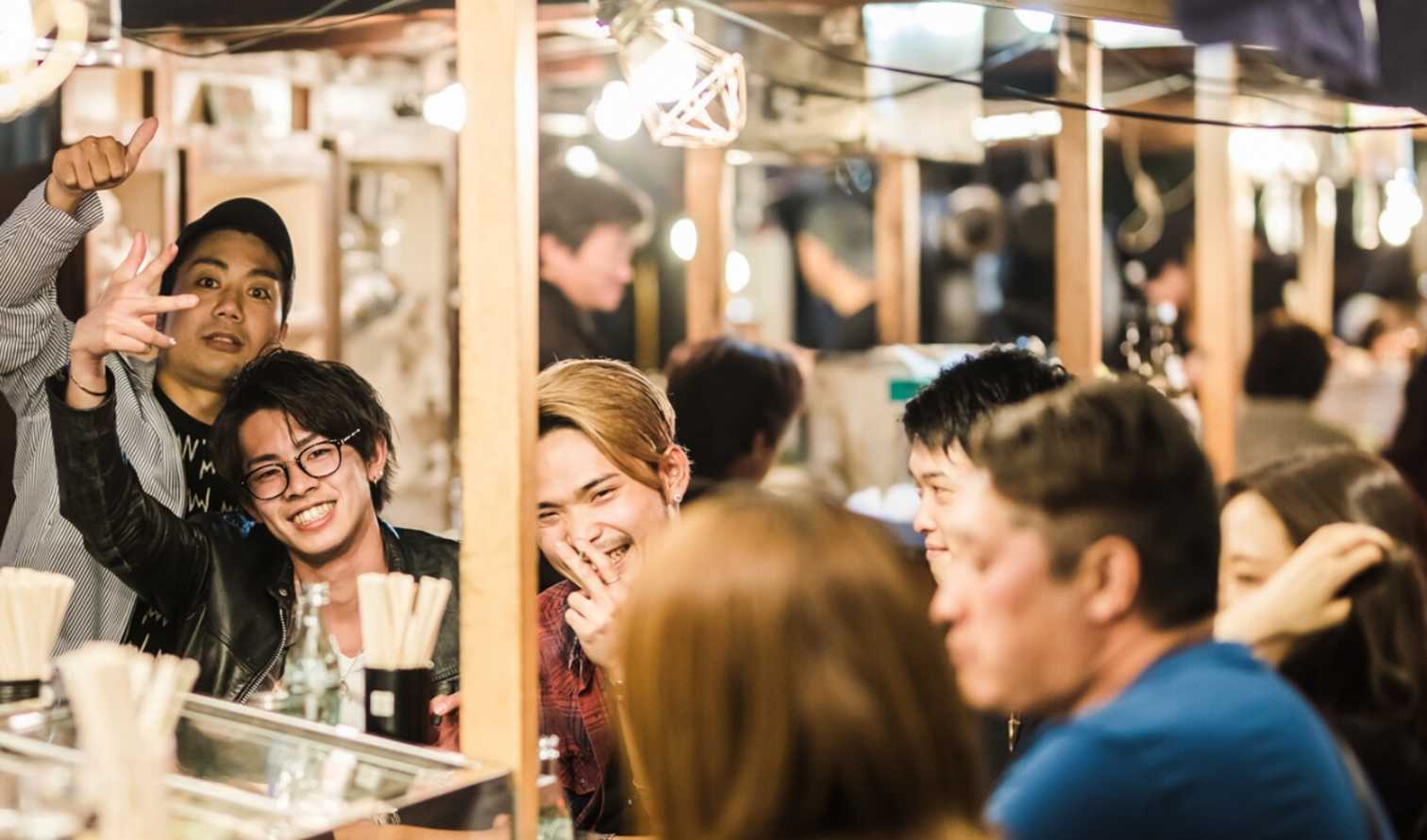 Group of people in a Japanese izakaya street food stall in Fukuoka