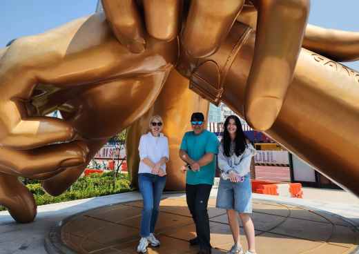 Golden Moments: Striking a Pose Under Giant Hands