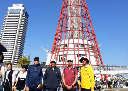 Group of people standing in front of Kobe Port Tower in Japan.
