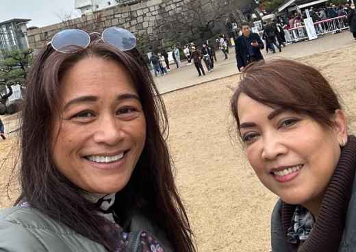 Two women taking a selfie in front of Osaka Castle.