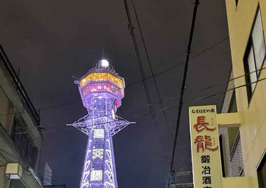 Tsutenkaku Tower illuminated at night in Osaka, Japan.