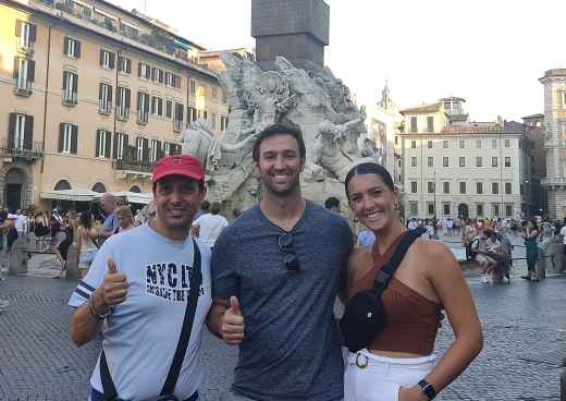 Three people posing in front of the Fountain of the Four Rivers, Piazza Navona.