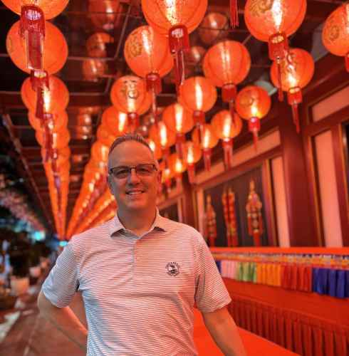 Illuminated Smiles Beneath a Sea of Red Lanterns