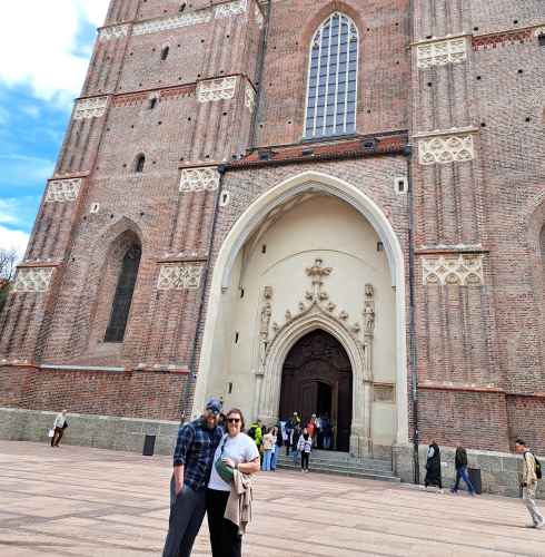 Facade of the Basilica di San Petronio in Munich with people walking outside.