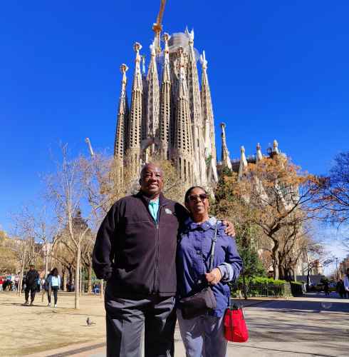 Two people pose in front of La Sagrada Família in Barcelona.