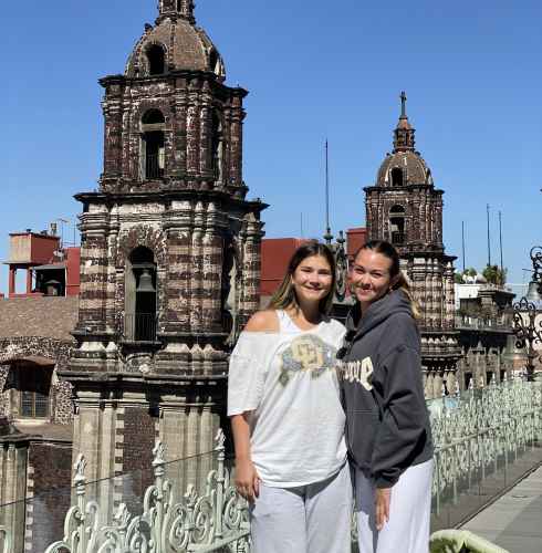 Close-up of cathedral towers in Puebla with two people nearby.