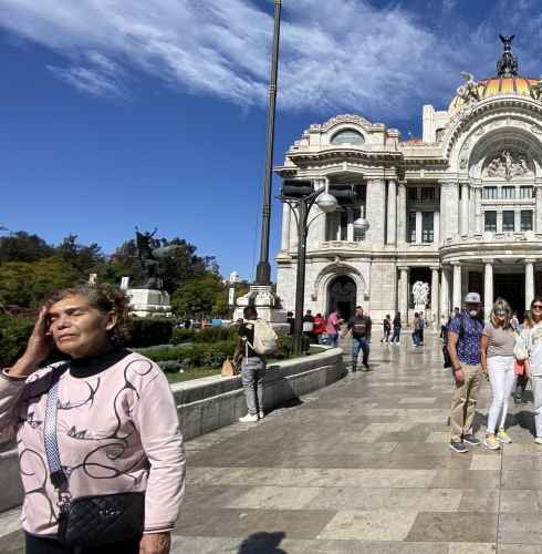 Visitors standing near Palacio de Bellas Artes entrance in Mexico City.