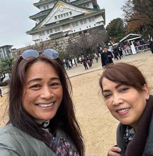 Two women taking a selfie in front of Osaka Castle.