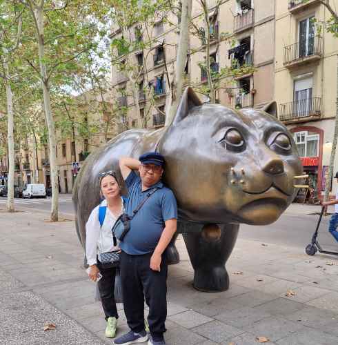 Two people stand beside the sculpture El Gato de Botero in Barcelona.