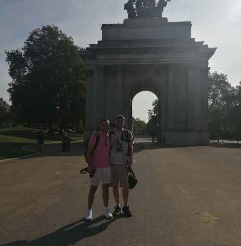 Two people standing in front of the Wellington Arch in London.