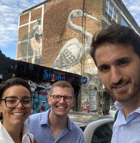 Street art featuring a large bird visible behind people on Brick Lane, London.