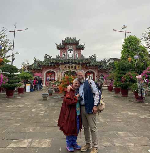 Two people standing in front of the Phuc Kien Assembly Hall entrance.