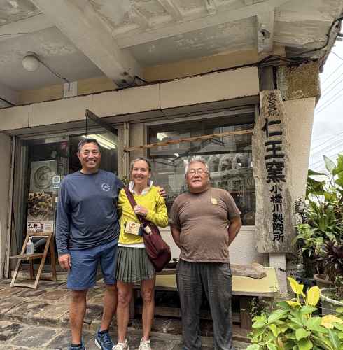 Exploring Naha's charm with warm smiles outside a pottery shop.