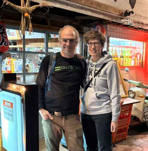 Exploring Naha's vibrant streets, they pause for a cheerful snapshot.