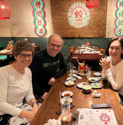 Sharing a laugh over local dishes in a cozy Naha restaurant.