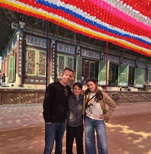 Three people standing in front of Jogyesa Temple in Seoul, South Korea.
