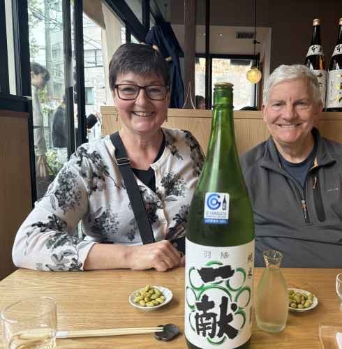 Two people sitting at a wooden table in a Japanese restaurant.