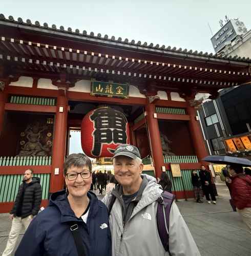 Visitors posing near the large red lantern of Kaminarimon Gate, Tokyo.