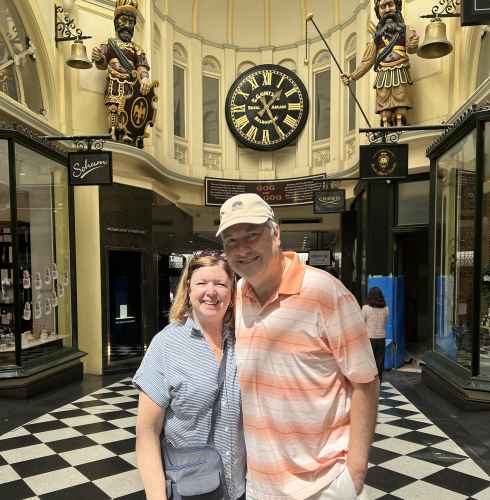 Two people standing in front of the clock at Royal Arcade, Melbourne.