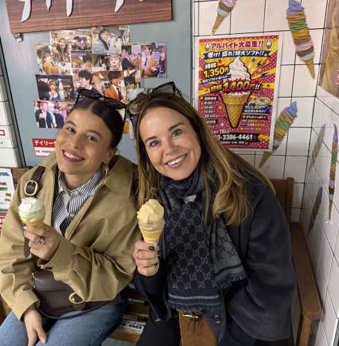 Two women enjoy ice cream at a bench inside a Japanese dessert store.