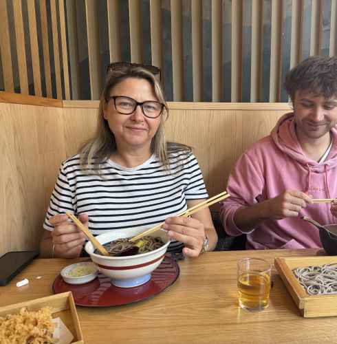 Two people dining at a Japanese restaurant table with soba noodles.