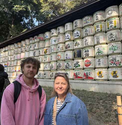 Visitors at Meiji Shrine with traditional sake barrels visible.