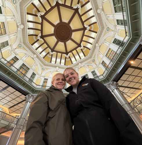 Upward view of Tokyo Station's interior dome with two people underneath.