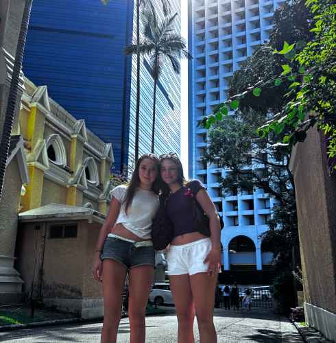 Tourists strolling under the skyscrapers in Hong Kong's midday sun.