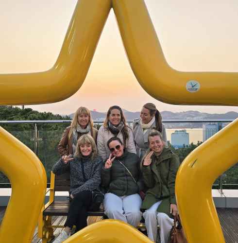 Laughter and peace signs under Busan's golden glow.