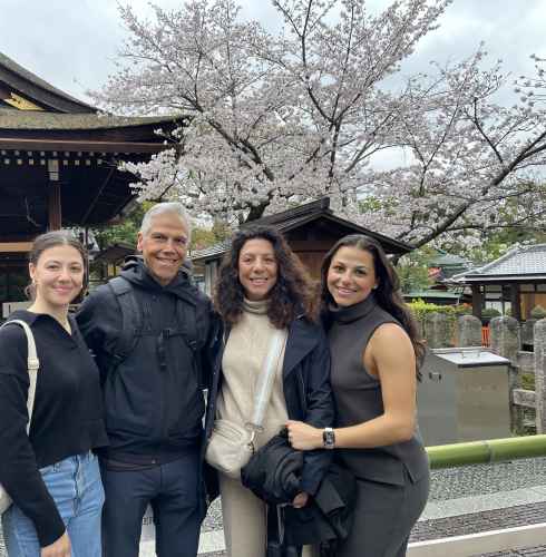 A cheerful group enjoys a cherry blossom moment in Kyoto.