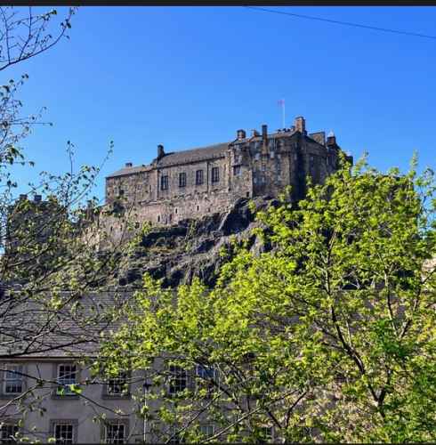 Edinburgh Castle stands majestically against a clear blue sky.