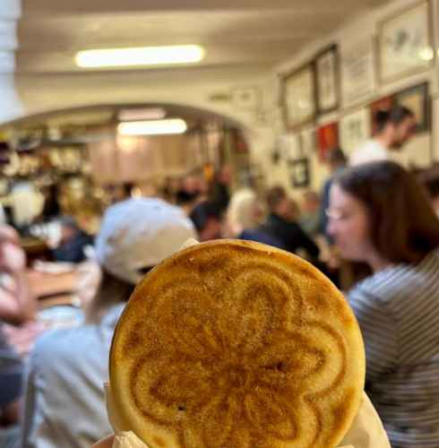 Sharing a warm pastry moment in vibrant Bologna.