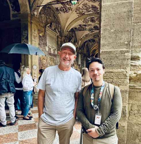Pausing under ornate arches in a Bologna courtyard.