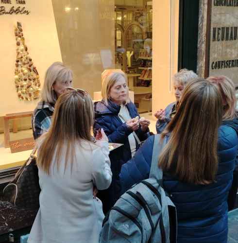 Savoring chocolate delights outside a cozy confectionery.