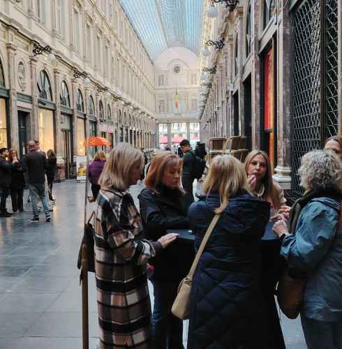 A group gathers around a shop window in Brussels' arcade.