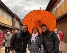 Under the Vibrant Canopy: A Warm Moment Amidst Rainy Skies
