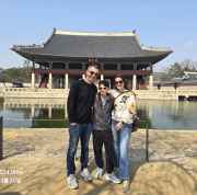 Family posing in front of Gyeonghoeru Pavilion at Gyeongbokgung Palace, Seoul.