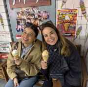 Two women enjoy ice cream at a bench inside a Japanese dessert store.