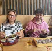 Two people dining at a Japanese restaurant table with soba noodles.