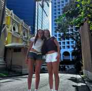 Tourists strolling under the skyscrapers in Hong Kong's midday sun.