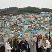 Friends pause for a photo with Busan’s colorful houses as backdrop.