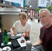 Tourists enjoying a quiet moment with coffee in bustling Hong Kong.